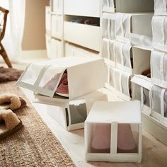 two boxes are open on the floor next to a teddy bear and slippers in front of them