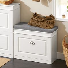 a white bench sitting next to a window in a room with two baskets on it