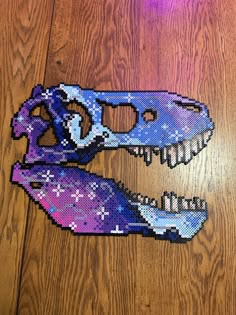 a purple and blue dinosaur skull on a wooden floor