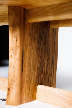 a close up of a wooden bench with a fork and knife stuck in the wood