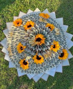 a bunch of sunflowers are arranged in the middle of a circular arrangement on grass