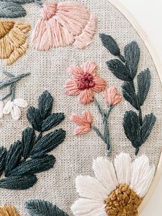 an embroidery project with flowers and leaves on it