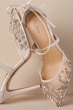 a pair of white wedding shoes with crystal embellishments