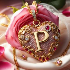 a heart shaped pendant with the letter p on it sitting next to a pink rose