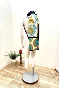 a mannequin wearing a colorful backpack on display in front of a white wall