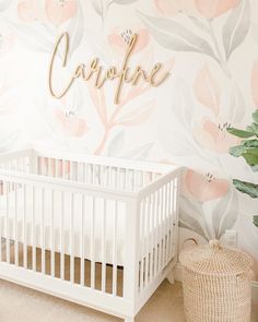 a white crib in front of a floral wallpaper with the word carpie on it