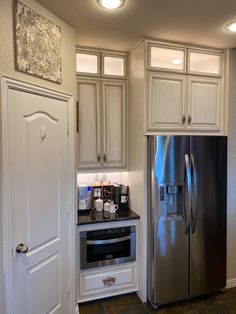 a kitchen with white cabinets and stainless steel appliances