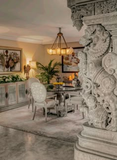 an ornately decorated dining room with white chairs and marble table in front of it