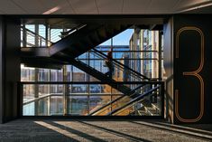 an open staircase leading to the upper level of a building with glass walls and steel railings