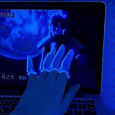 a person's hand is touching the screen of a laptop computer that has been turned on