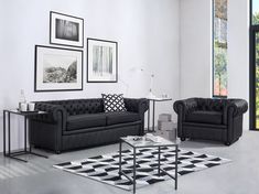 a black and white living room with two couches, a coffee table and pictures on the wall