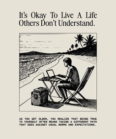 a man sitting at a table on top of a beach