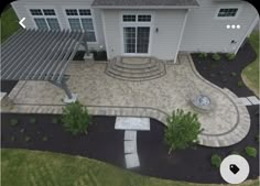 an aerial view of a large house with landscaping and patio area in the foreground