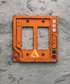 an orange electrical outlet cover on the side of a wall