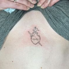 a woman's stomach with a small tattoo design on the back of her body