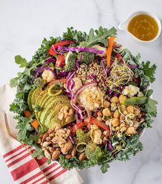 a salad with broccoli, carrots, red cabbage and peanuts on it