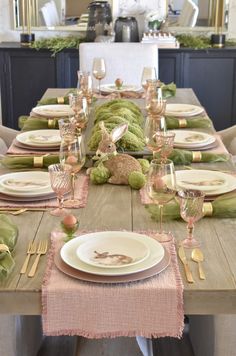 the table is set with plates, silverware and pink napkins for an easter bunny themed dinner