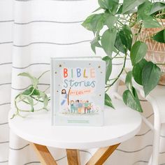 a book sitting on top of a white table next to a potted plant