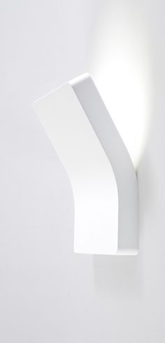 a white wall light mounted on the side of a wall