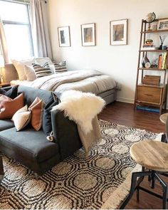 a living room filled with furniture and lots of pillows on top of a rug in front of a window