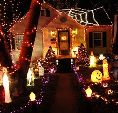 a house decorated for halloween with pumpkins and lights