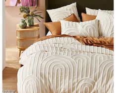 a bed with white and brown comforters in a room