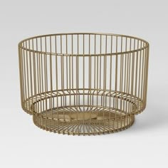 a gold metal wire basket sitting on top of a table