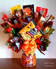 a jar filled with candy and candies sitting on top of a wooden table next to a wall