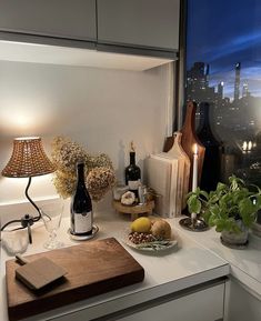 a kitchen counter with a cutting board, wine bottle and other food items on it