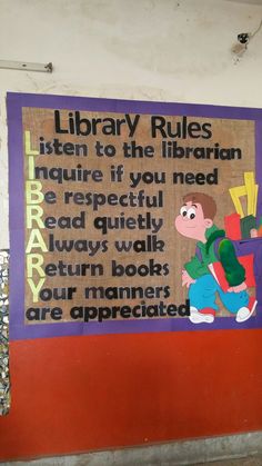 a sign on the side of a building that says library rules