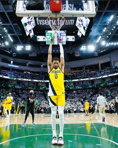 a basketball player is getting ready to dunk the ball in front of an audience