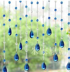 blue glass beads hanging from the side of a window