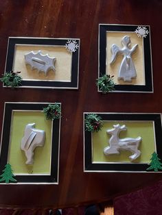 four framed christmas decorations on a table