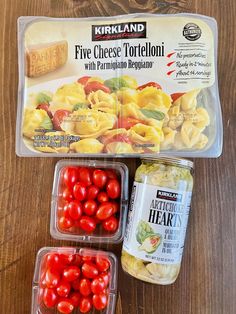 three plastic containers filled with different types of pasta and tomatoes on top of a wooden table