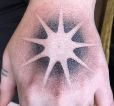 a person's hand with black and white ink on it, showing the star