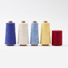 four spools of thread lined up in different colors