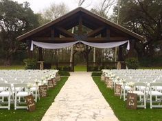 an outdoor wedding setup with white chairs