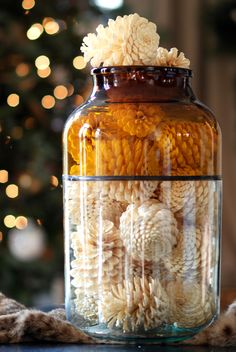 a glass jar filled with pasta shells next to a christmas tree