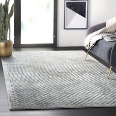 a living room area with a couch, chair and potted plant on the floor