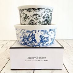 three bowls sitting on top of each other in front of a white box with blue and black designs