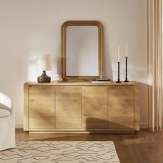 a living room with a large mirror on the wall and a wooden dresser in front of it