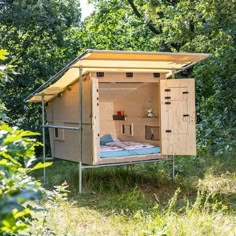 an outhouse in the woods with its doors open