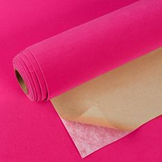 a roll of pink paper sitting on top of a table