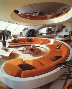 an orange and white living room with circular couches on the floor, round coffee table