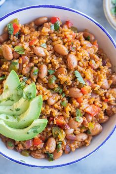 a bowl filled with beans and avocado on top of a blue table cloth