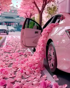 a pink car parked on the side of a road with flowers all over it's sides