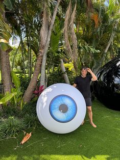 a man standing next to an inflatable blue eyeball