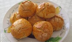 a white plate topped with bread rolls on top of a table