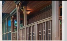 the front porch is covered with wooden slats and has a lantern light on it