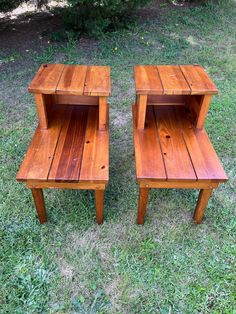 two wooden tables sitting on top of a grass covered field